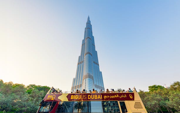 Open-top Big Bus tour in Dubai with Burj Khalifa in the background.