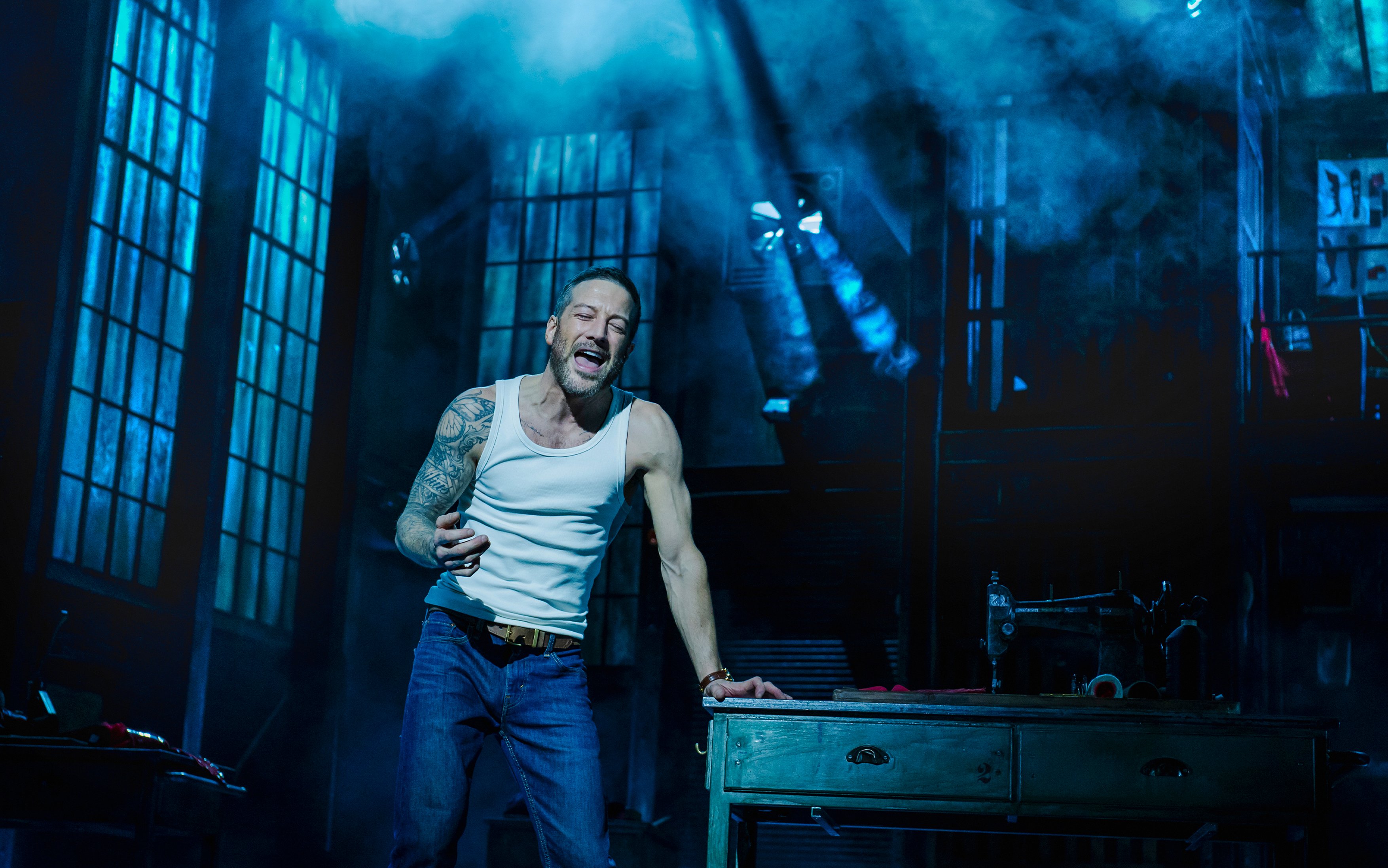 Performer singing passionately on stage during Kinky Boots production.