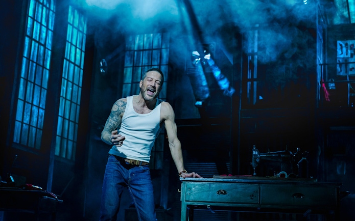 Performer singing passionately on stage during Kinky Boots production.