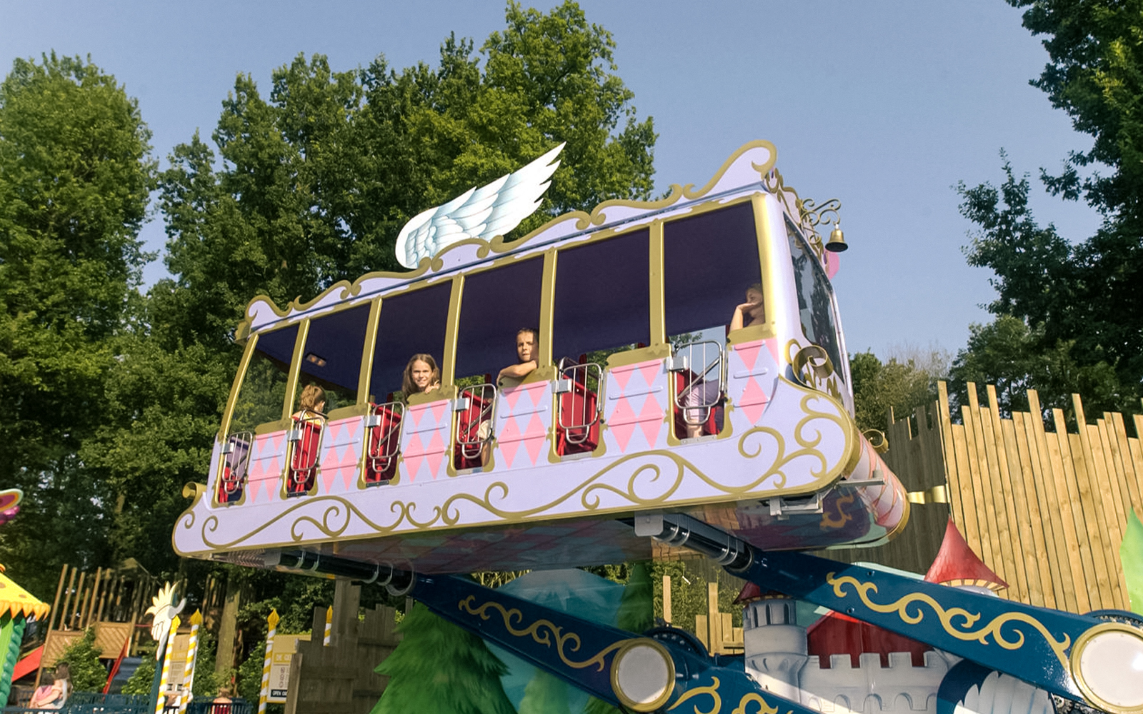 Promenade en calèche dans le parc Bellewaerde avec des chevaux colorés et des cavaliers enthousiastes.