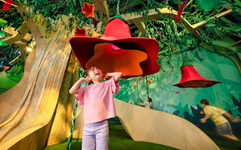 Child exploring interactive SingingTree at Forestland's Curiosity Cove.