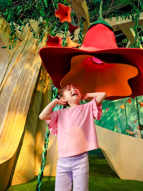 Child exploring interactive SingingTree at Forestland's Curiosity Cove.