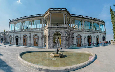 Chapultepec Castle exterior with fountain and visitors in Mexico City.