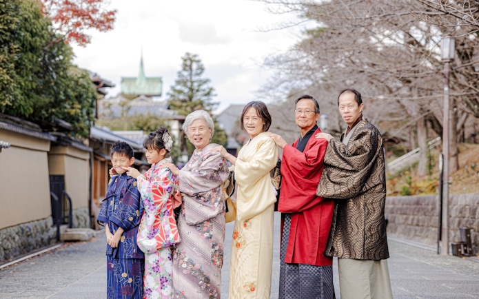Family in traditional kimonos on a historic street in Kyoto, Japan.