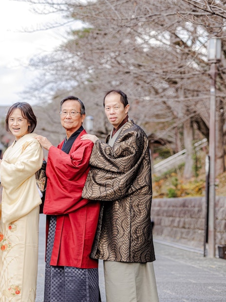 Family in traditional kimonos on a historic street in Kyoto, Japan.