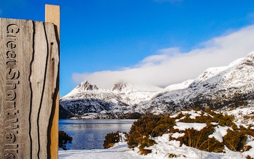 Cradle Mountain view with snow-covered peaks and lake, sign for Great Short Walk.