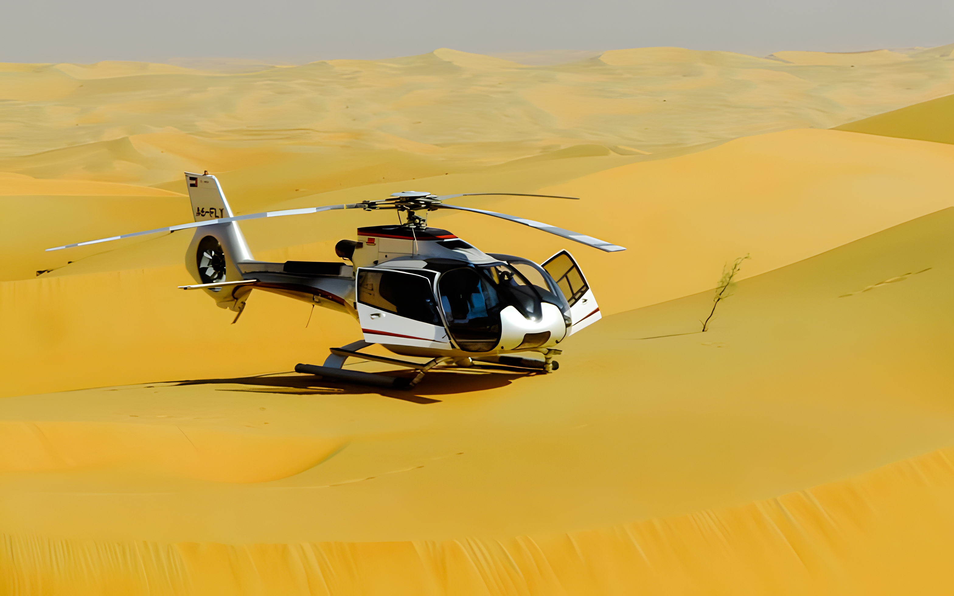 Helicopter on sand dunes in Dubai desert.