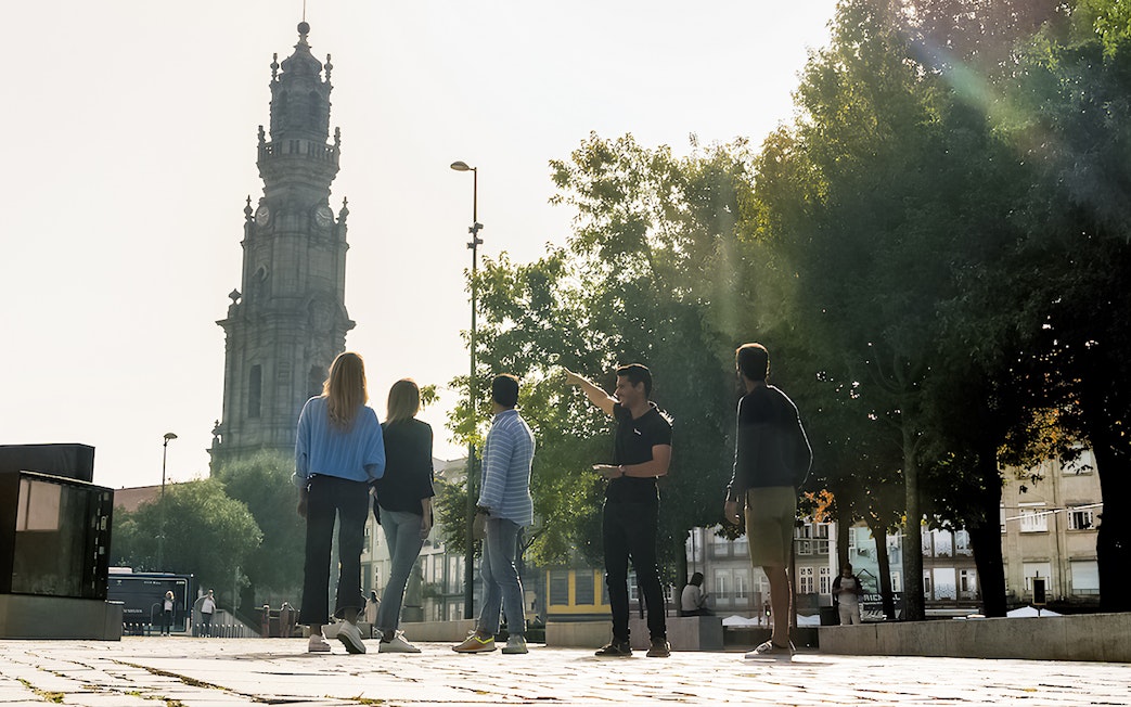 Tourists with guide near Clérigos Tower on Porto walking tour.