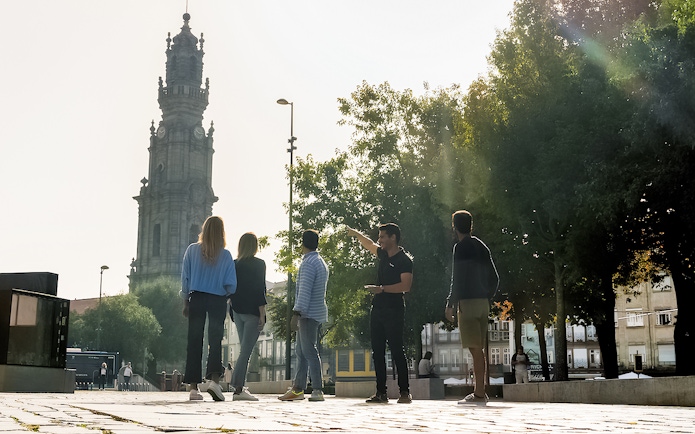 Tourists with guide near Clérigos Tower on Porto walking tour.