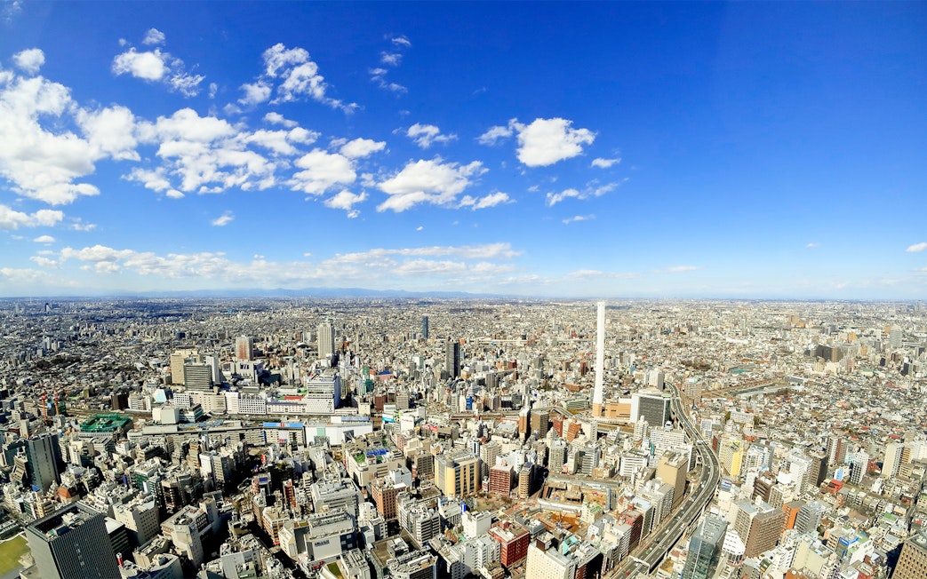 Aerial view of Tokyo skyline near Sunshine Aquarium, clear blue sky.