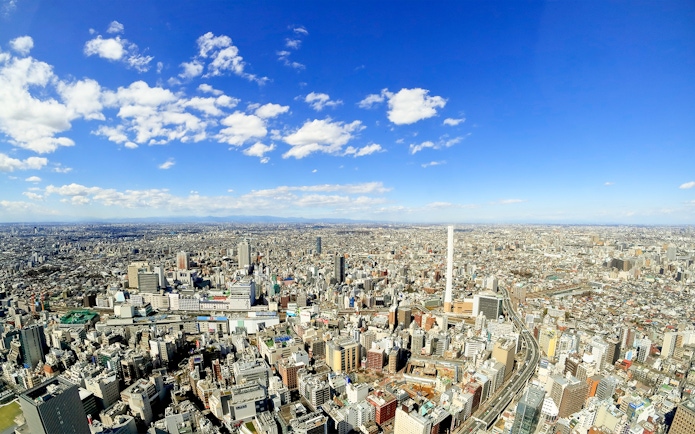 Aerial view of Tokyo skyline near Sunshine Aquarium, clear blue sky.