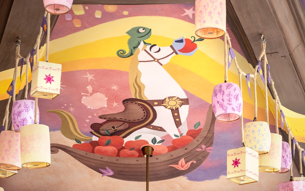Mural of a horse and chameleon with lanterns at Disneyland's World of Frozen, inspired by Tangled.