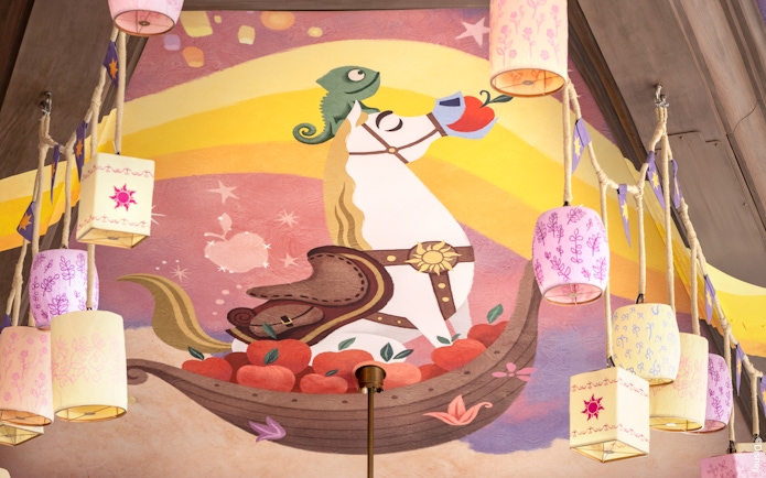 Mural of a horse and chameleon with lanterns at Disneyland's World of Frozen, inspired by Tangled.