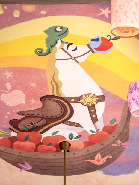 Mural of a horse and chameleon with lanterns at Disneyland's World of Frozen, inspired by Tangled.