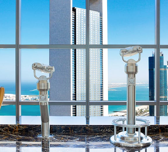 Etihad Tower Observation Deck view with telescopes overlooking Abu Dhabi skyline.