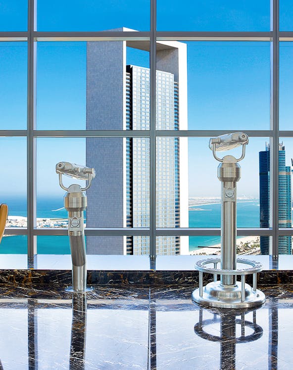 Etihad Tower Observation Deck view with telescopes overlooking Abu Dhabi skyline.