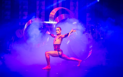 Performer in dynamic pose with hoops and smoke, 90s Forever show.