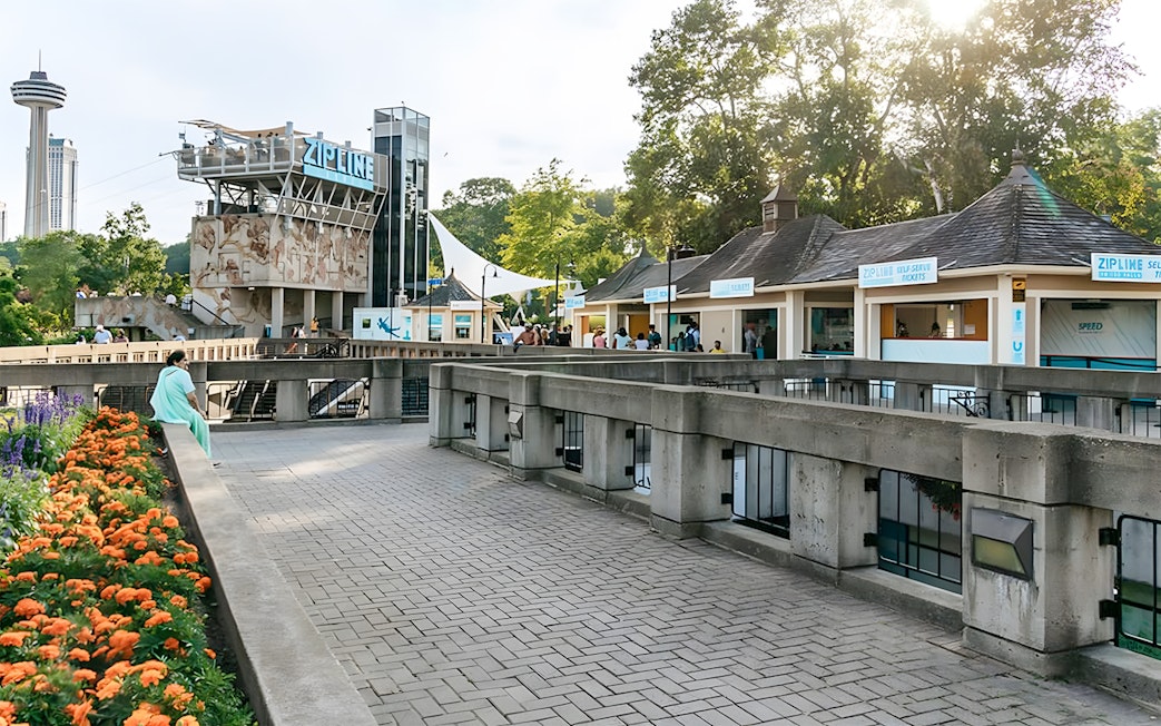 Zipline launch platform near Niagara Falls with ticket booths and observation tower.