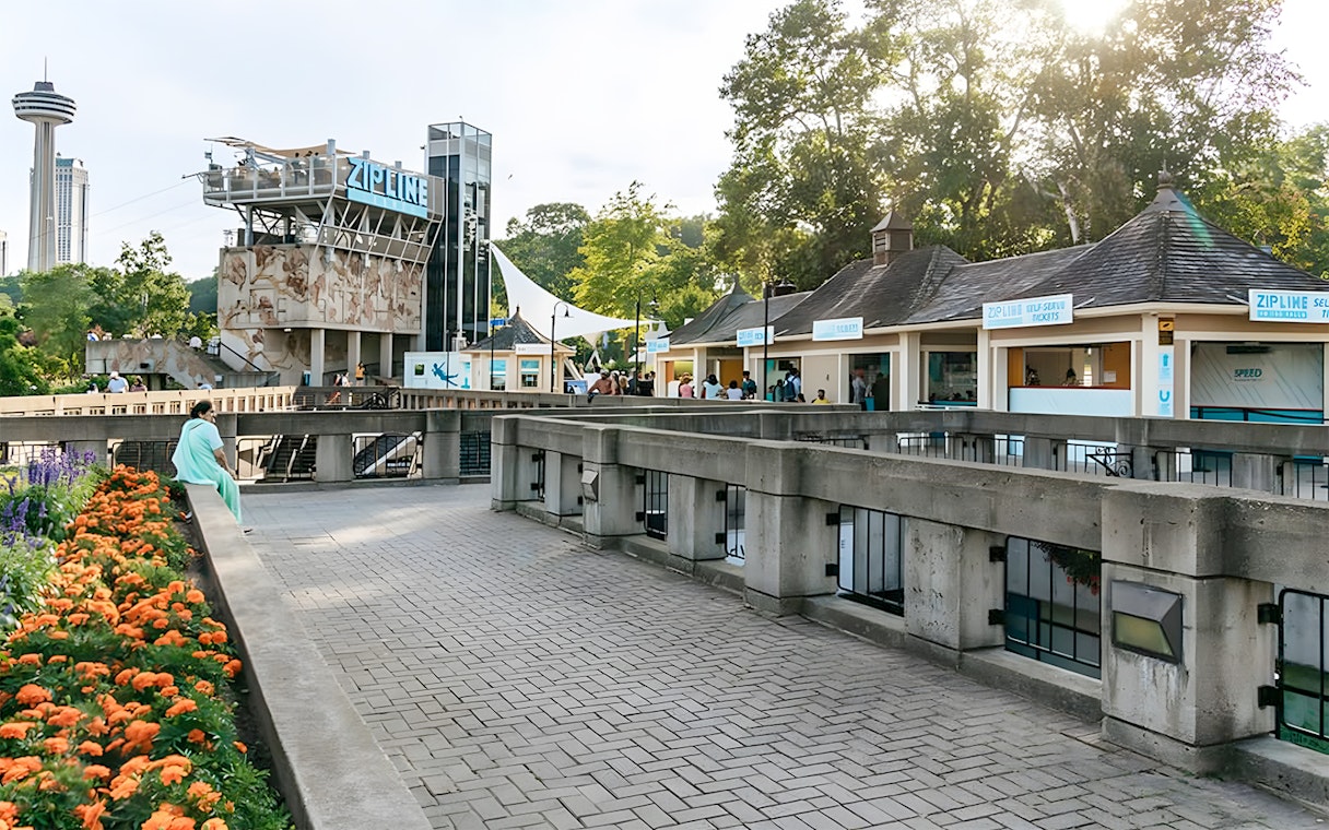 Zipline launch platform near Niagara Falls with ticket booths and observation tower.