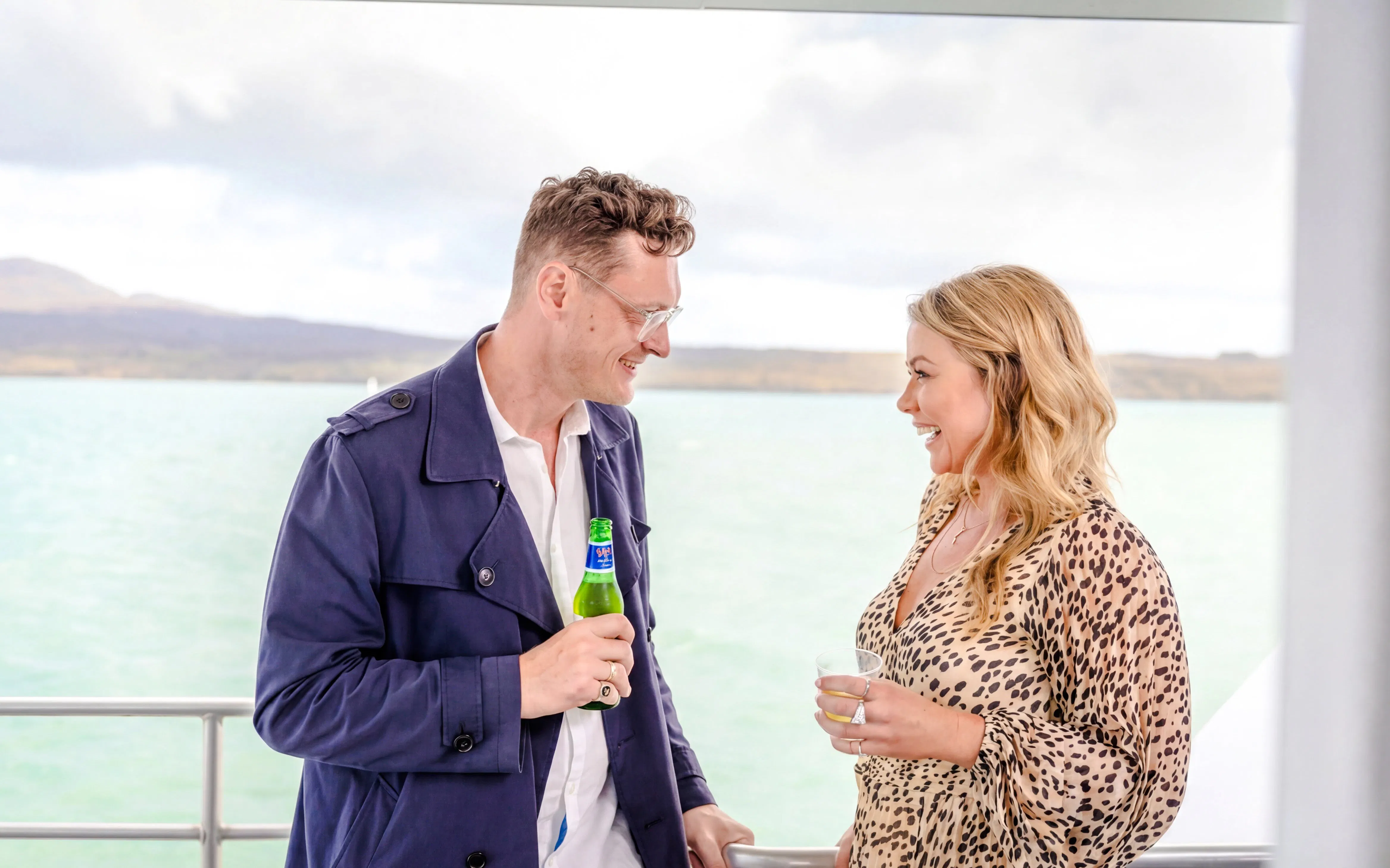 Couple enjoying drinks on Auckland Harbour sightseeing cruise.