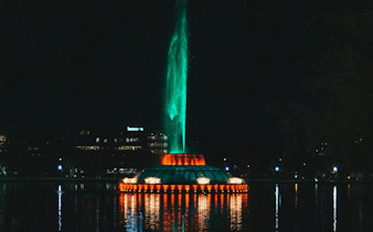 Night view of illuminated fountain at Lake Eola, Orlando, part of Haunted Orlando exploration game.