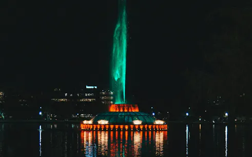 Night view of illuminated fountain at Lake Eola, Orlando, part of Haunted Orlando exploration game.