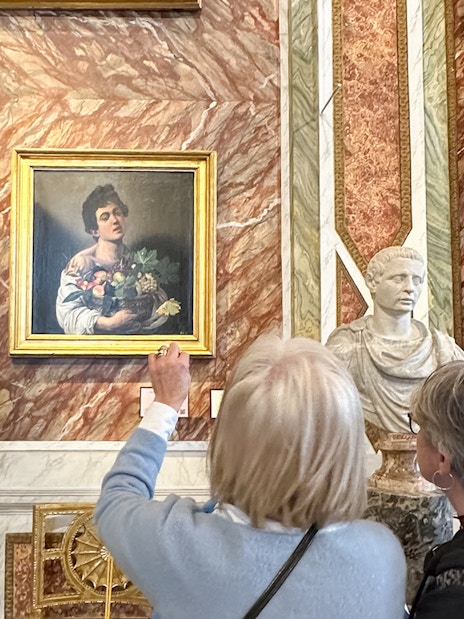 Visitors viewing Caravaggio's "Boy with a Basket of Fruit" at Borghese Gallery, Rome.