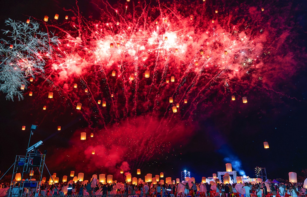 Fireworks and floating lanterns illuminate the night sky at Yi Peng and Loy Krathong Festival 2025 in Thailand.