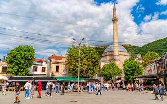 Crowd in Shadervan Square, Prizren, Kosovo, with Sinan Pasha Mosque in the background.