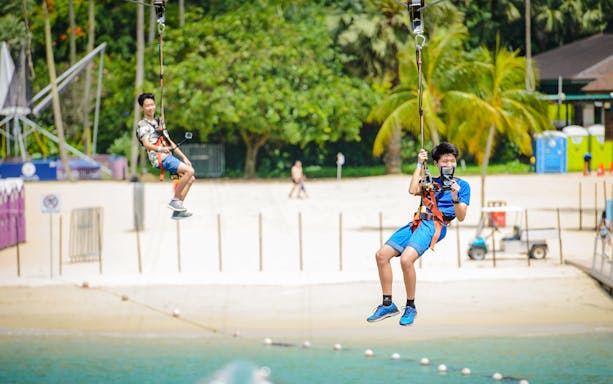 Visitors ziplining over the beach at Mega Adventure Park, Singapore.