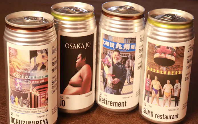 Cans featuring sumo-themed labels from Ochiizumibeya, showcasing sumo wrestlers and events.