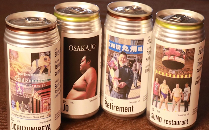 Cans featuring sumo-themed labels from Ochiizumibeya, showcasing sumo wrestlers and events.