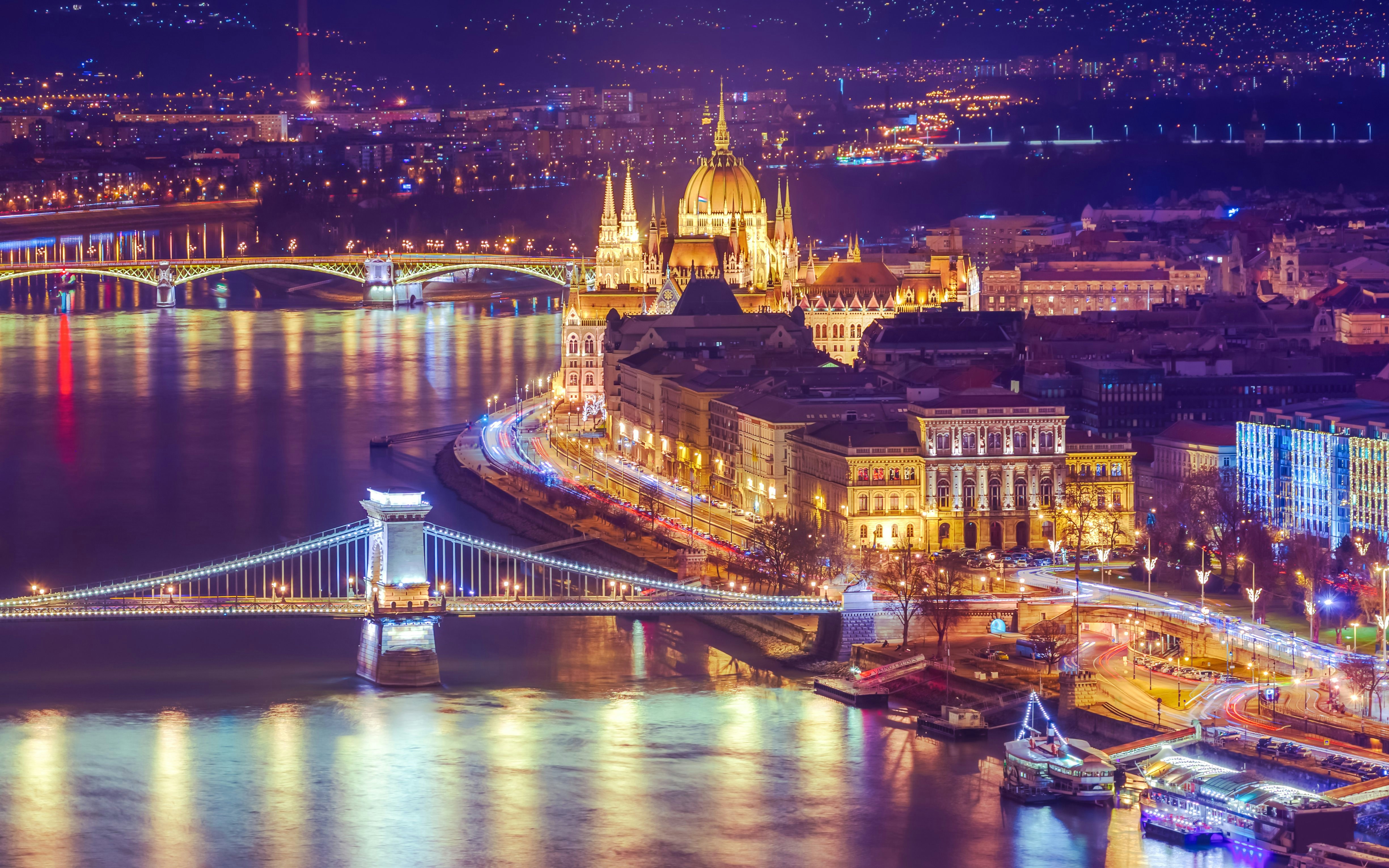 Budapest Parliament and Chain Bridge illuminated at night during Danube Christmas cruise.
