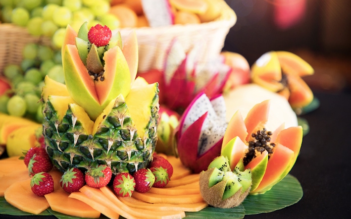Fruit arrangement at Le Bistro Parisien dinner, featuring pineapple, papaya, and strawberries.