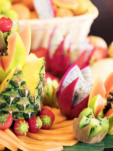 Fruit arrangement at Le Bistro Parisien dinner, featuring pineapple, papaya, and strawberries.