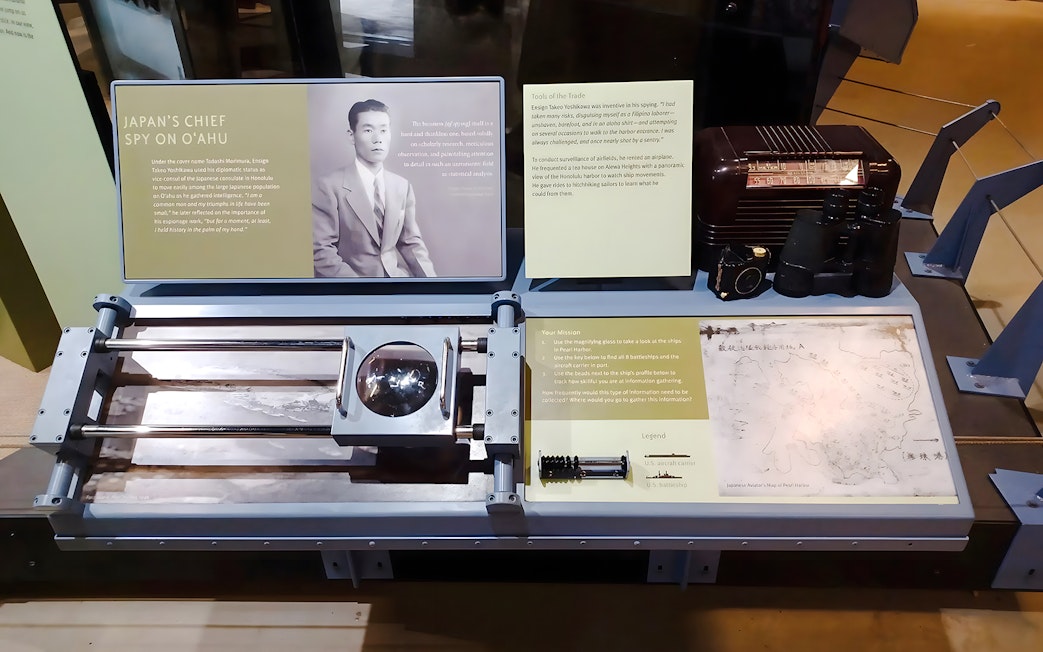 Display of espionage tools and information related to the USS Arizona tour at Pearl Harbor.