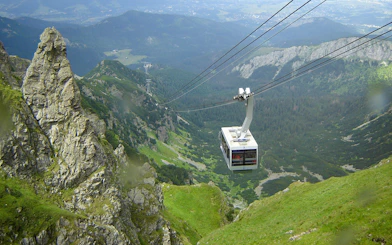 Cable car ascending over green mountains in Zakopane, Poland.