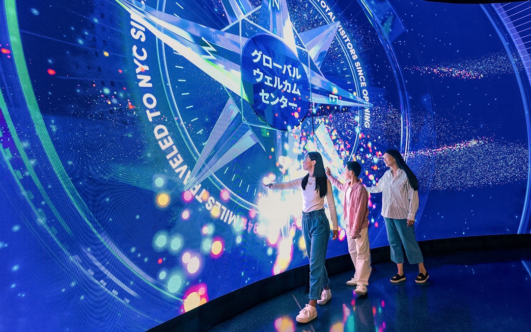 Visitors interacting with digital display at Welcome Wall, One World Observatory, New York City.