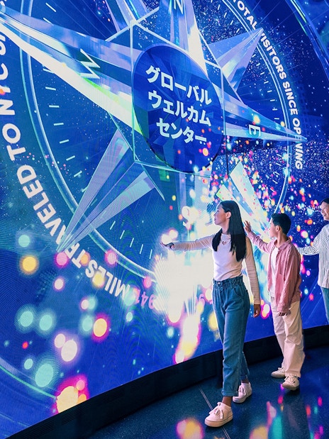 Visitors interacting with digital display at Welcome Wall, One World Observatory, New York City.