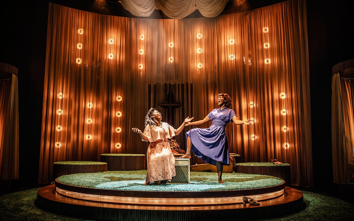 Two performers on stage in a Marie & Rosetta production, surrounded by warm lighting.