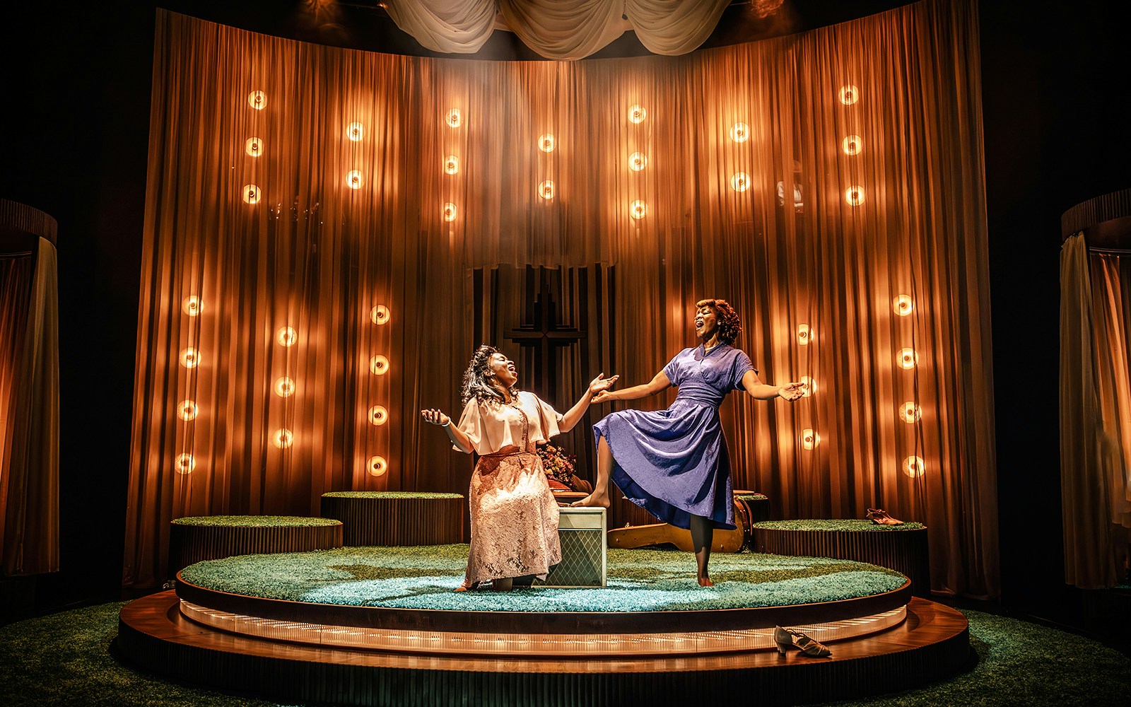 Two performers on stage in a Marie & Rosetta production, surrounded by warm lighting.