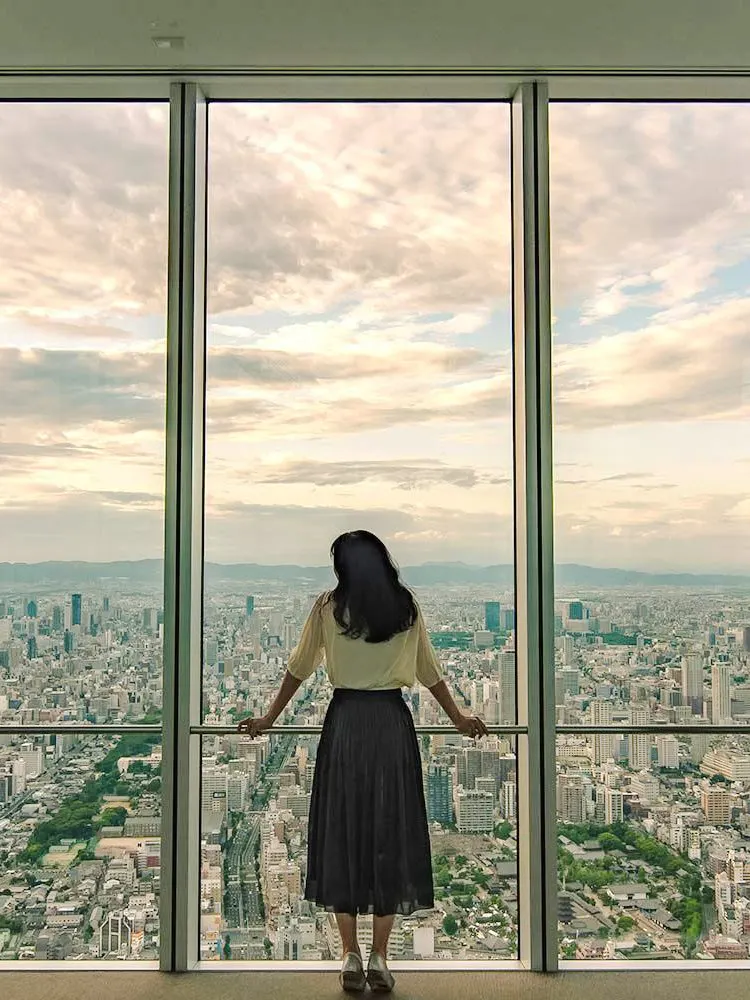 Woman viewing Osaka skyline from Harukas 300 Observatory.