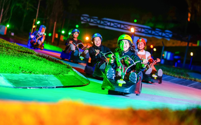 People enjoying a night ride on Skyline Luge track.