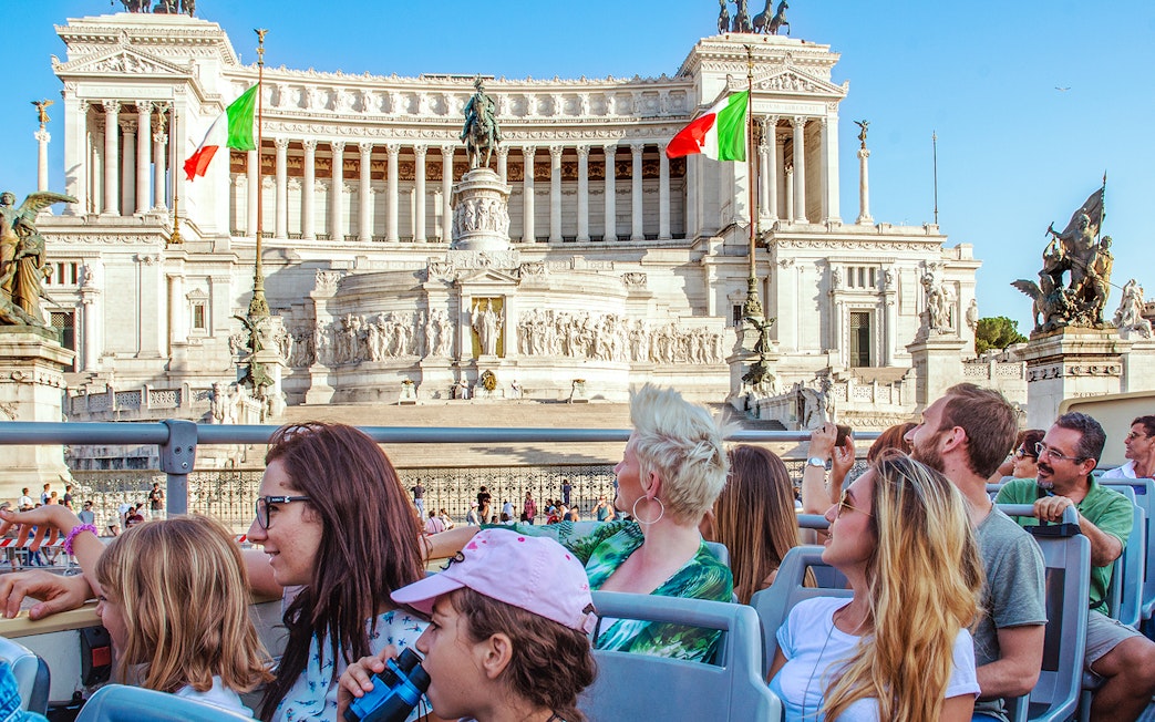 People on a HOHO bus viewing the Victor Emmanuel II Monument in Rome.