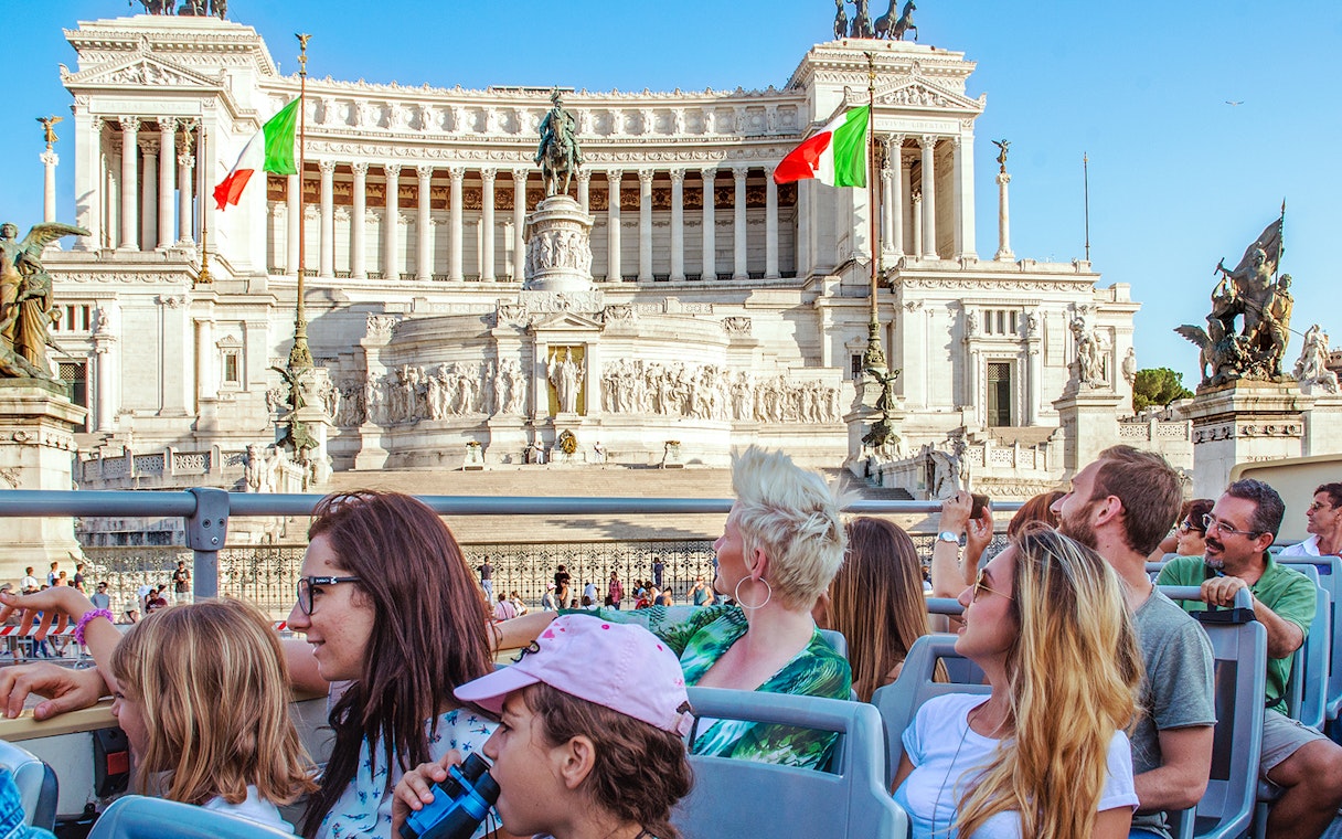 People on a HOHO bus viewing the Victor Emmanuel II Monument in Rome.