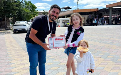 Tour guide with certificate and children at Cappadocia Red Tour meeting point.