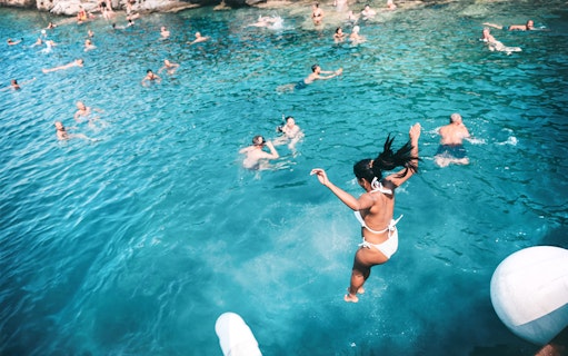 Jumping into Blue Lagoon waters during Papanikolis Cruise from Benitses/Lefkimmi.