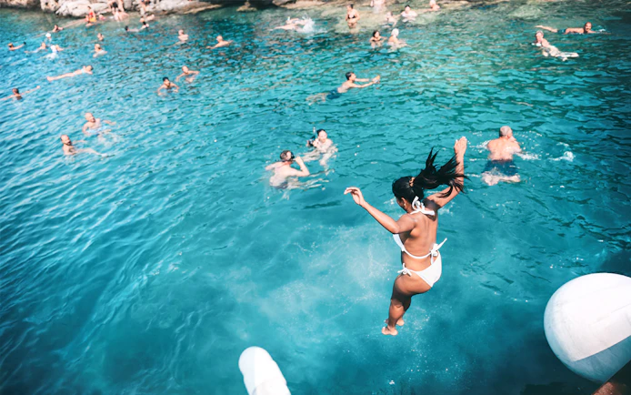 Jumping into Blue Lagoon waters during Papanikolis Cruise from Benitses/Lefkimmi.