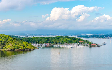 Hovedoya Island marina with boats and lush greenery in Oslofjord, Norway.