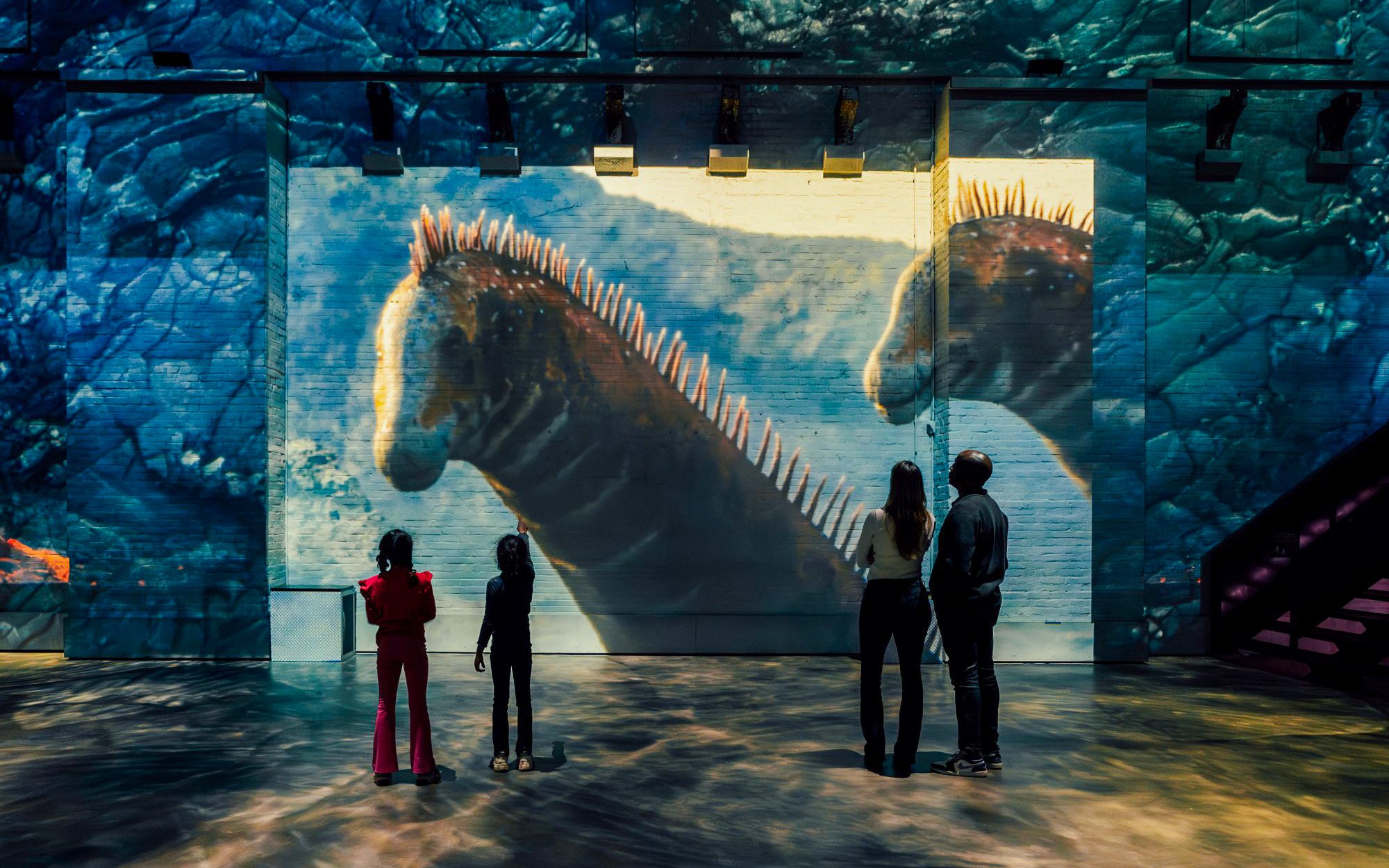 Visitors viewing dinosaur projections at Dino Exhibition, Fabrique des Lumières.
